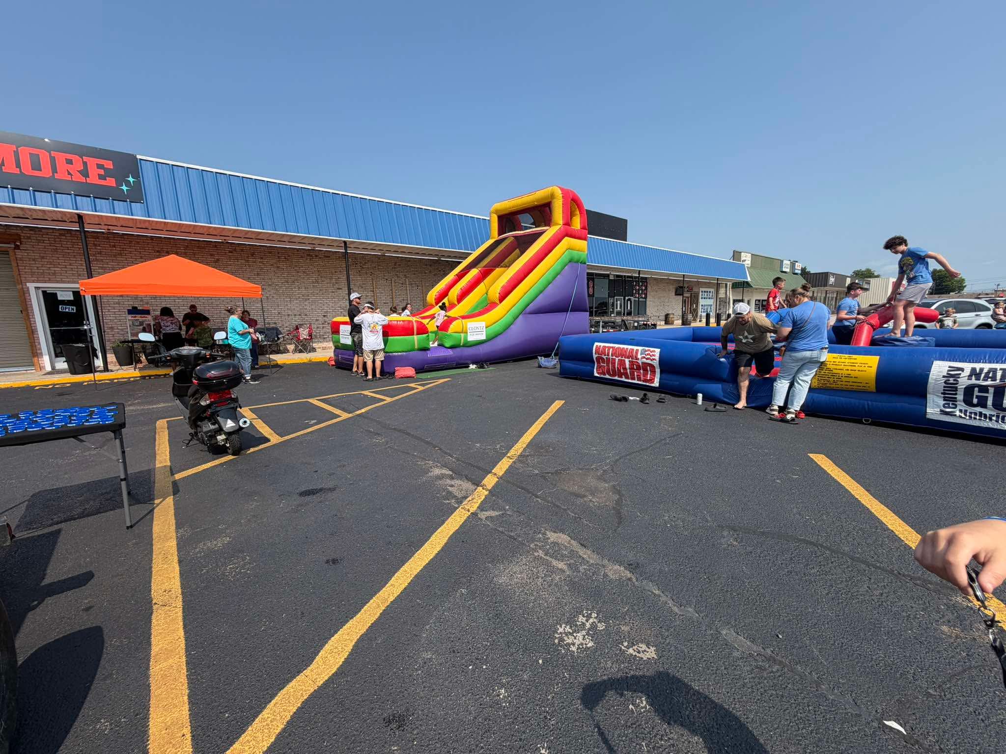 Children enjoying colorful inflatables and family activities during Community Care Day
